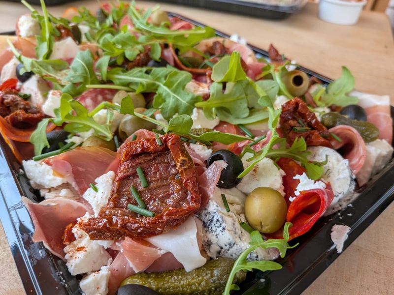An antipasti platter of cured meats, goat's cheese, olives, sun-dried tomatoes and rocket