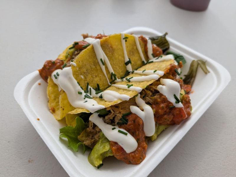 Crunchy tacos filled with pulled pork, guacamole and salsa, drizzled with sour cream
