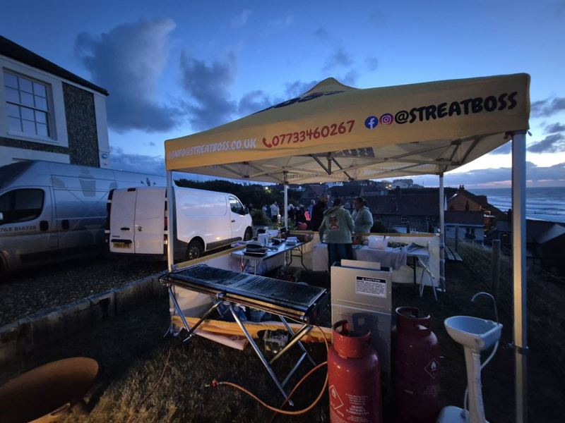 The Streat Boss gazebo and grill set up on a clifftop at dusk with the sea behind