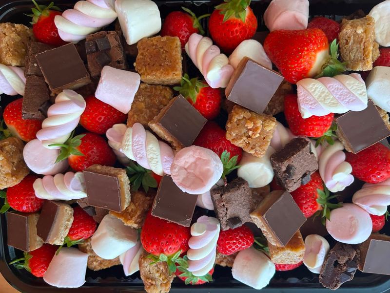 A platter of strawberries, marshmallows, brownies and millionaire's shortbread