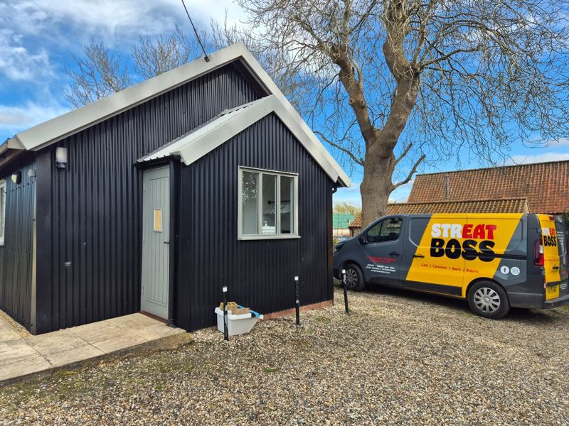 The Streat Boss van parked beside a black timber village hall
