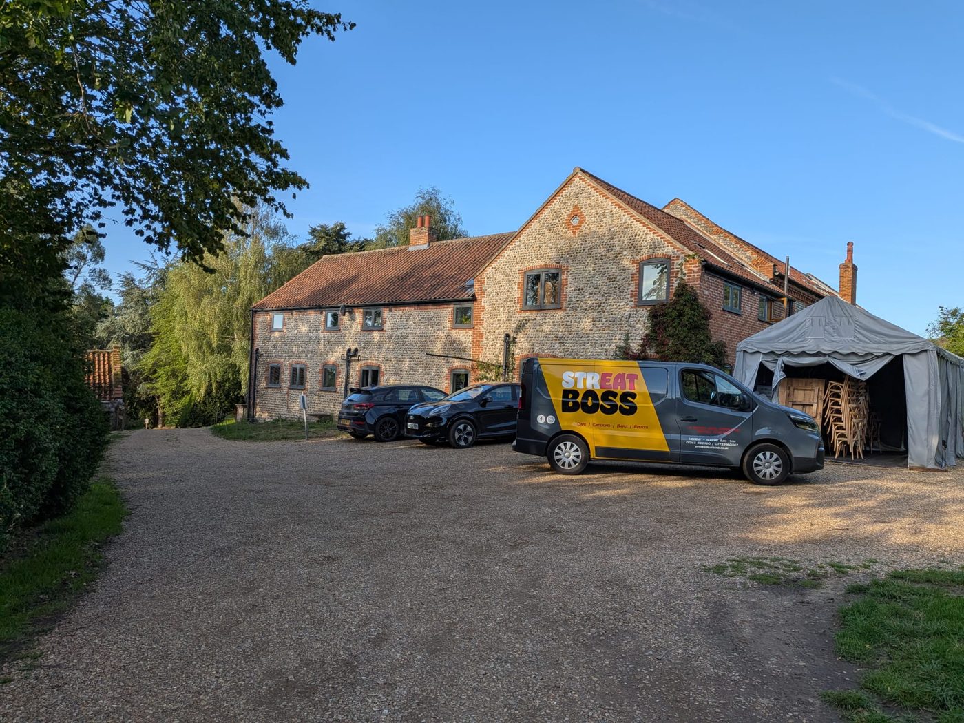 The Streat Boss van parked outside Chaucer Barn, a flint and brick barn wedding venue